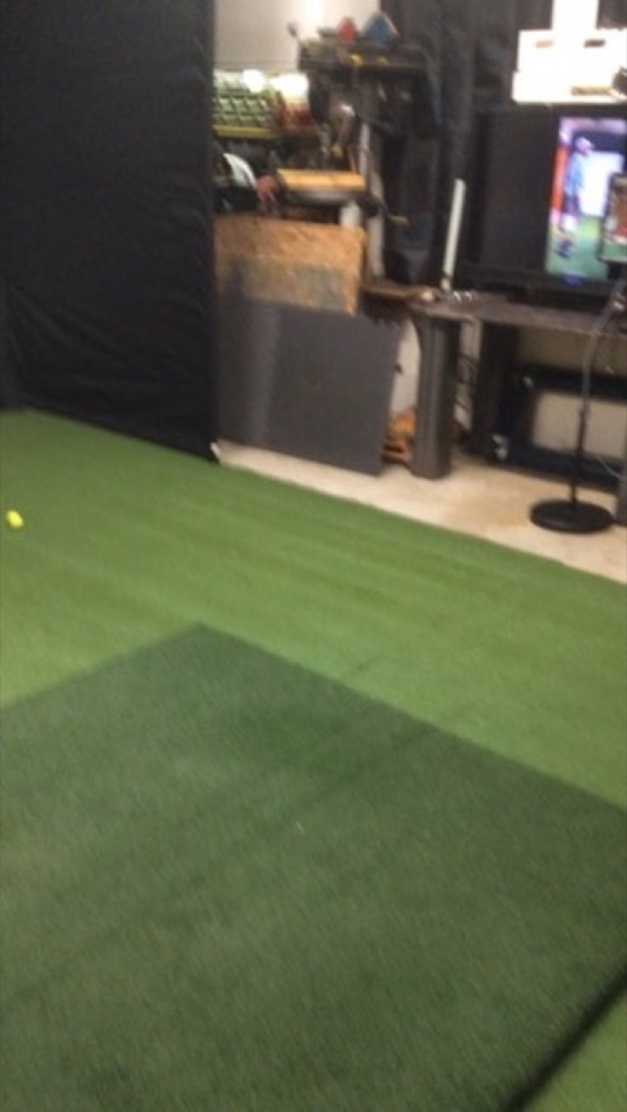 V2 putting green carpet with TV in corner