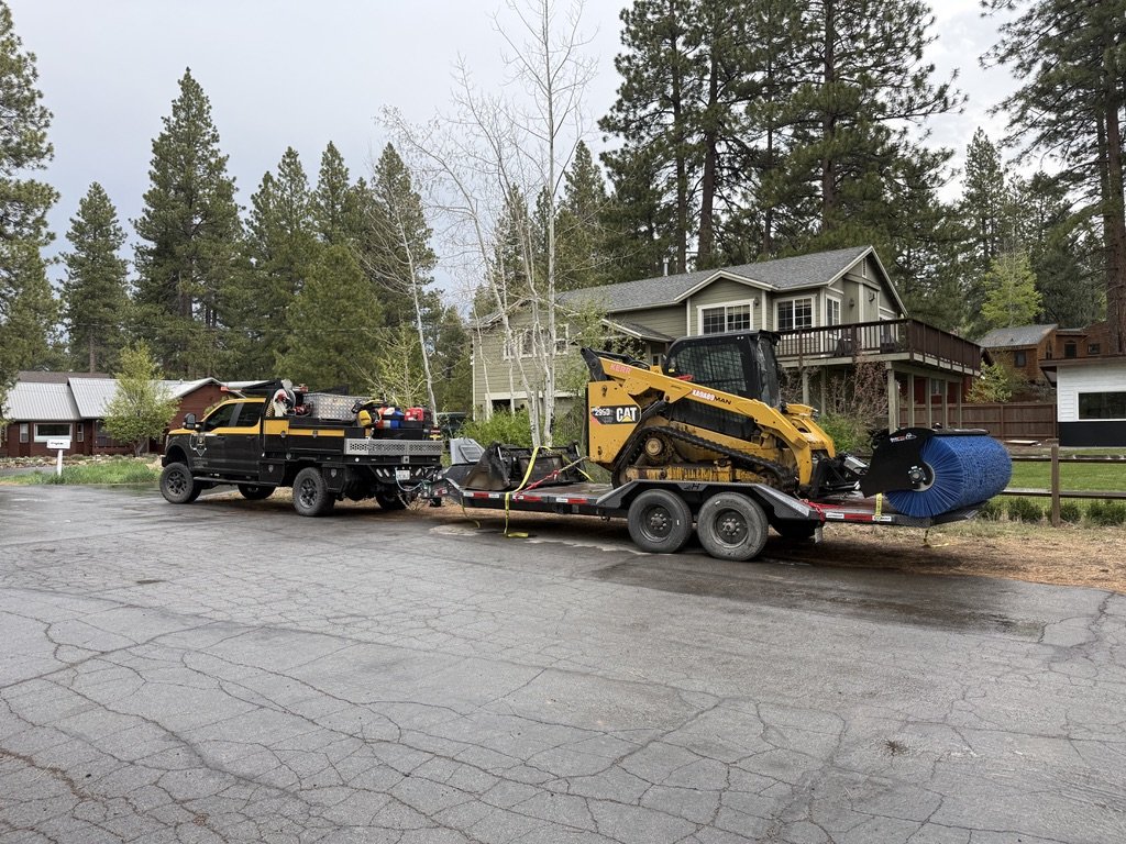 The side yard before — strip of dirt between house and property line, equipment staged for demo