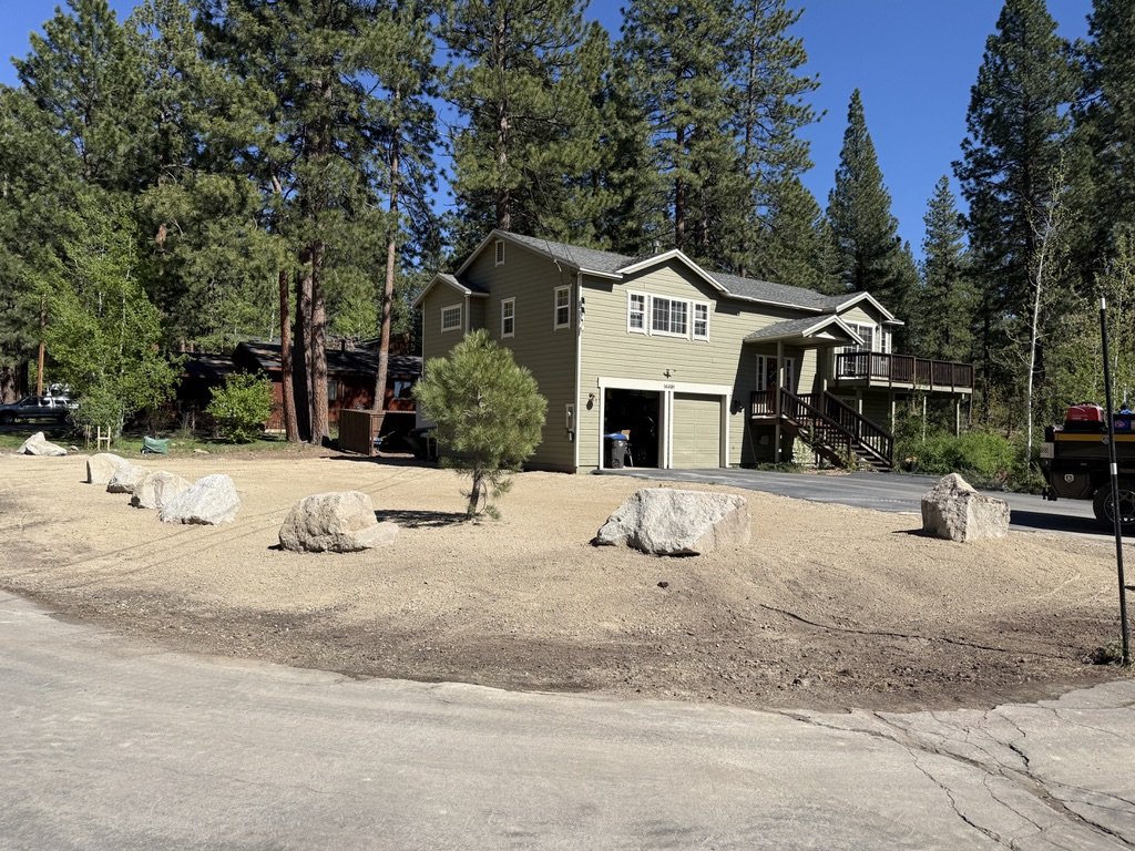 Reveal shot showing white Truckee home with the new boulder retaining feature