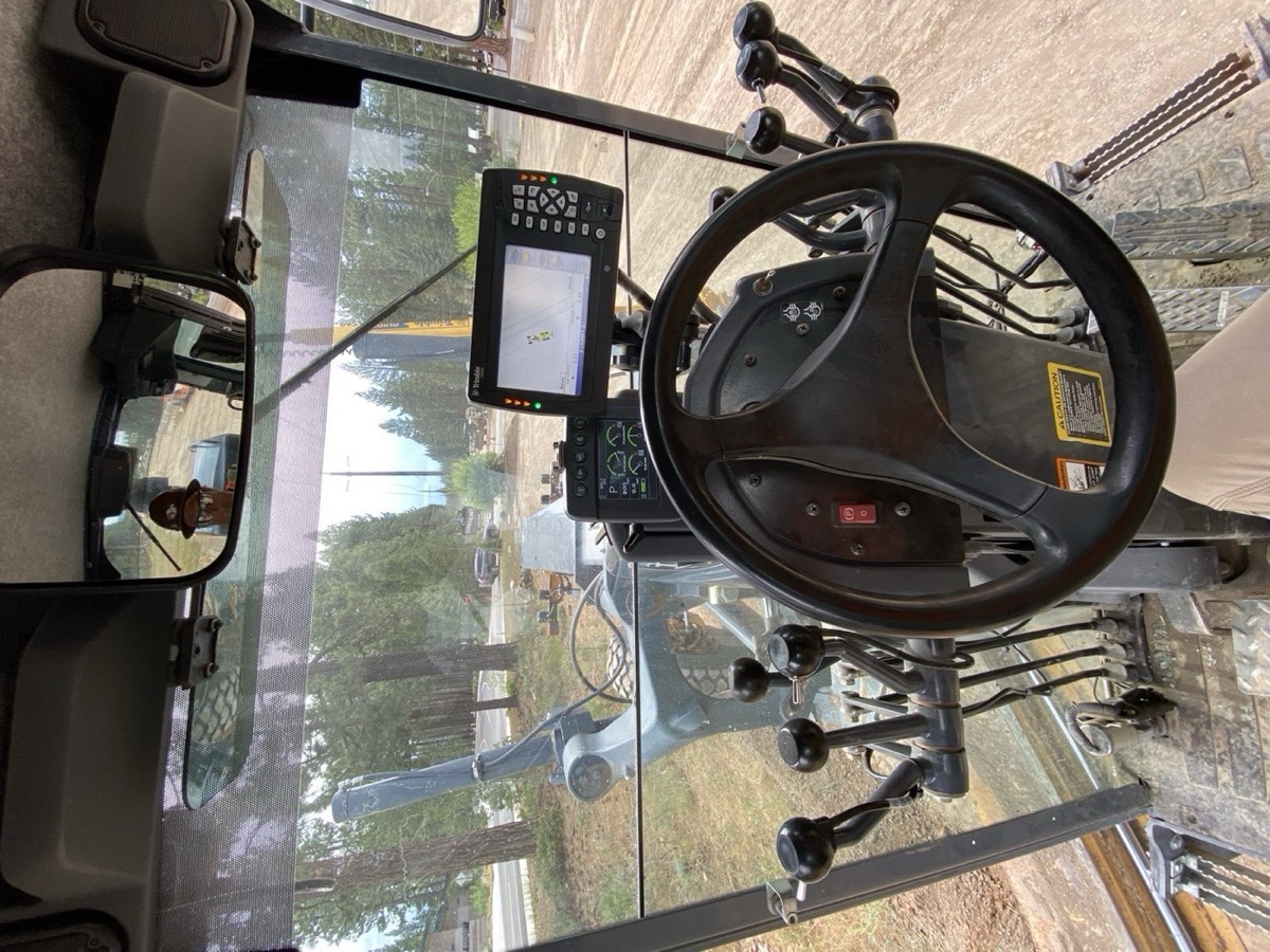 Inside the cab of a motor grader running Trimble GPS machine control on a Truckee jobsite — display mounted at the windshield