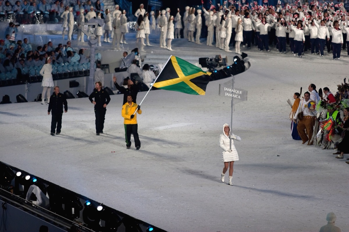 Errol Kerr carrying the Jamaican flag into BC Place Stadium behind the JAMAIQUE placard at the 2010 Vancouver Olympics Opening Ceremony