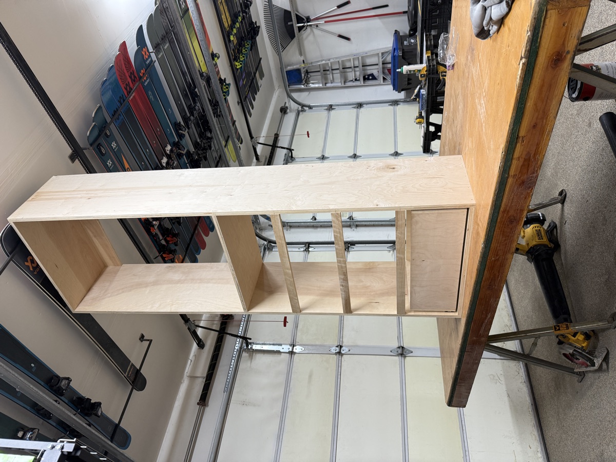 Finished plywood shelving tower with banded edges and a drawer