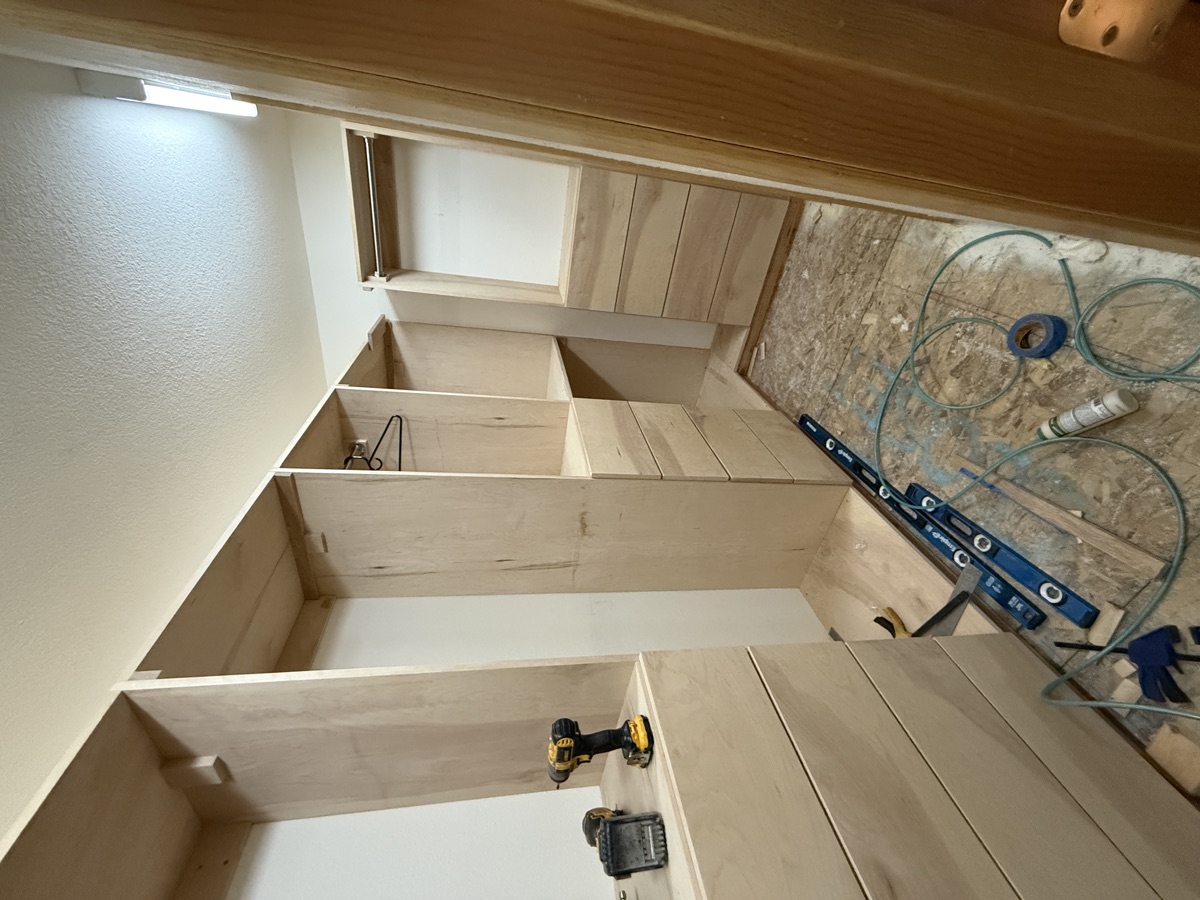 Walk-in closet with LED strip lighting illuminating the built-in shelving