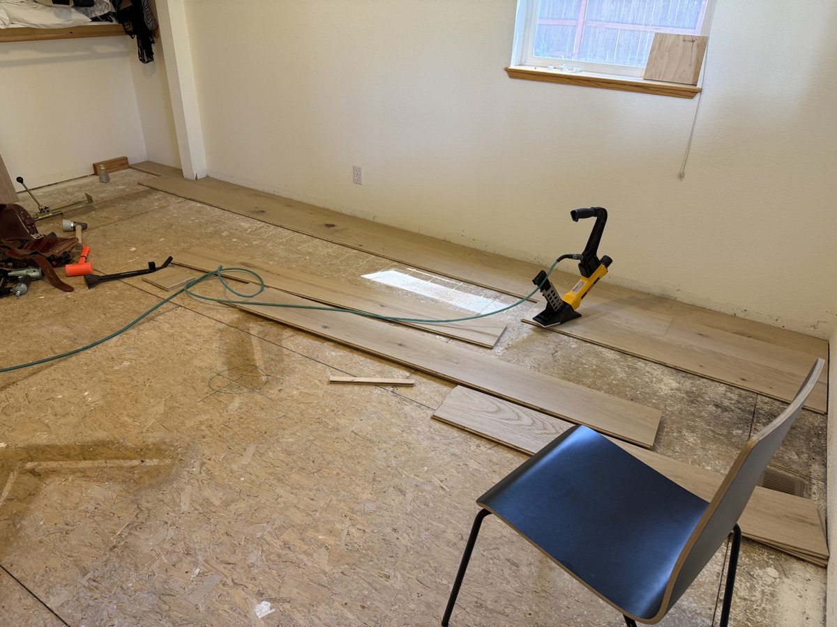 Early hardwood installation with about a quarter of the bedroom covered