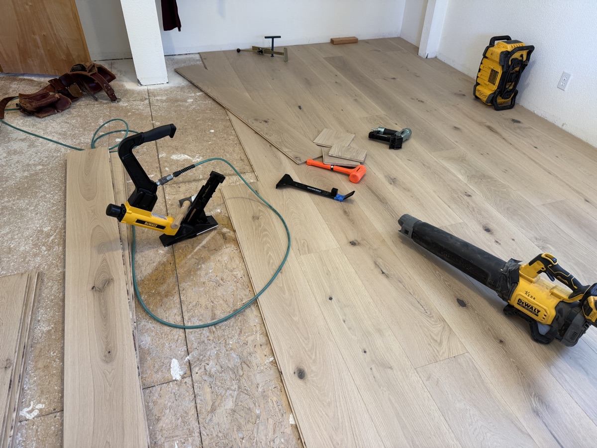 Hardwood floor mid-install showing stagger pattern across the room
