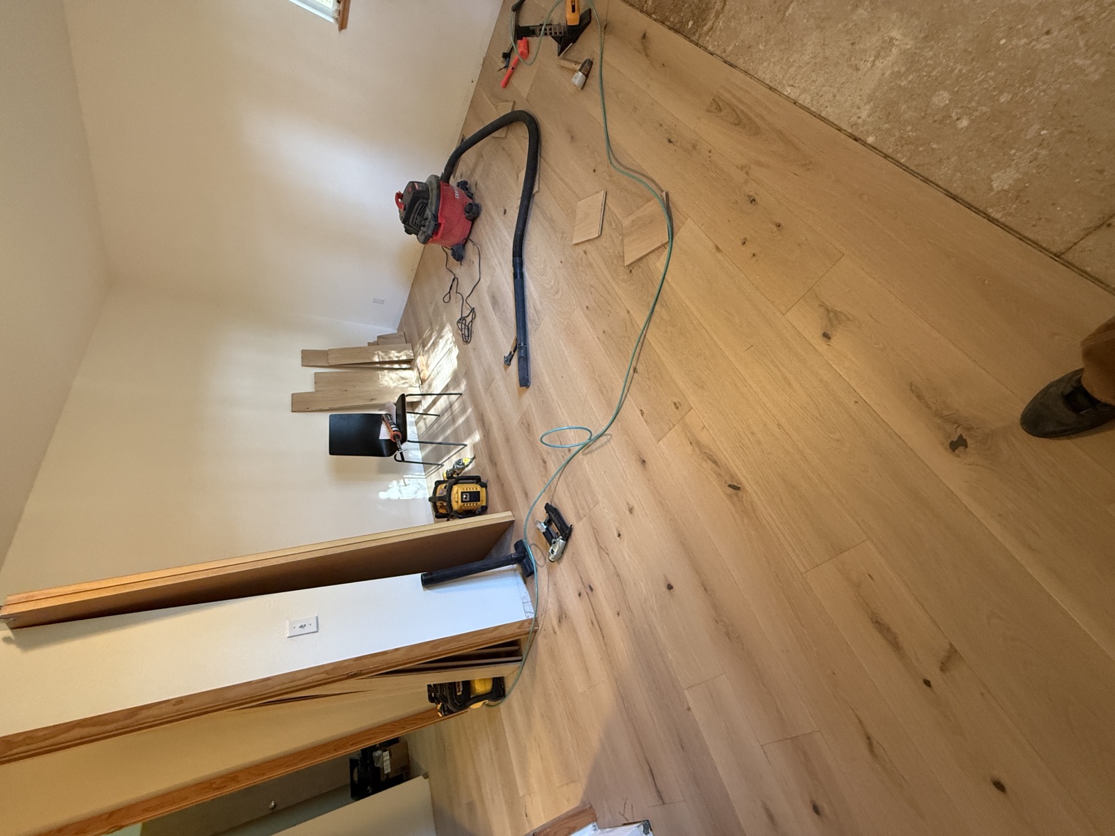 Wide-plank white oak hardwood floor mid-installation in main living area