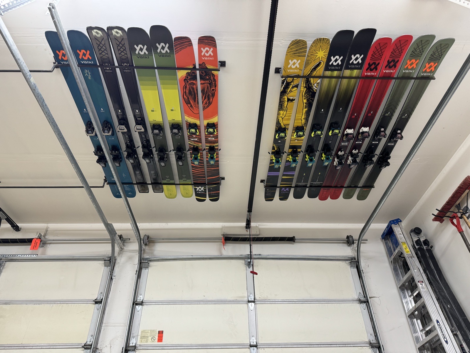 Close-up of Völkl skis mounted on ceiling racks above garage doors