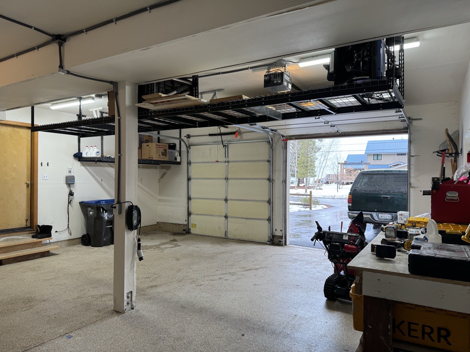 Overhead storage racks above garage doors with one door open