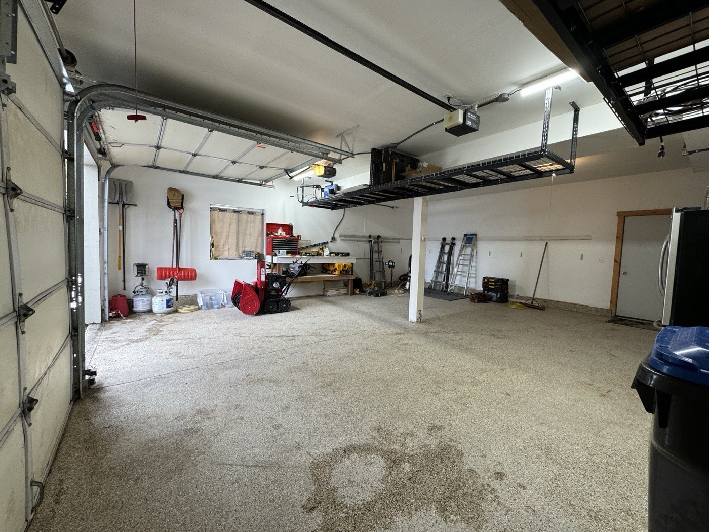 Garage interior with both doors up showing overhead rack clearance